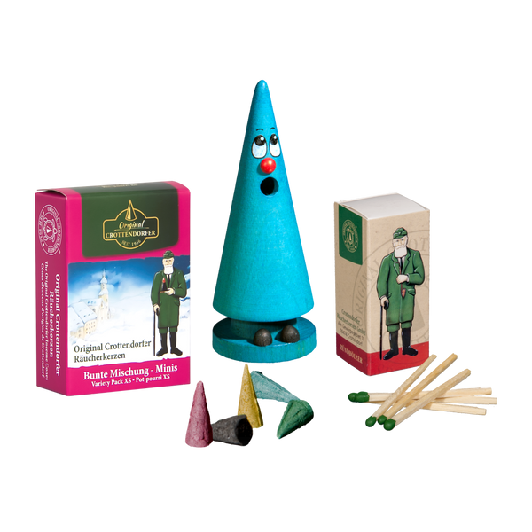 Das Mini-Räucherset ‚Leo Lavendel‘ von Original Crottendorfer Räucherkerzen beinhaltet einen türkisfarbenen, gesichtsförmigen Räucherkegel, bunte Räucherkerzenkegel, Streichhölzer und eine illustrierte Verpackungsschachtel und bietet so ein zauberhaftes und einzigartiges Räuchererlebnis.