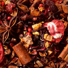Eine Nahaufnahme der Original Crottendorfer Früchteteemischung "Winterbeerchen", eine lebendige Mischung mit Trockenfrüchten, Sternanis, Zimtstangen, rosa Pfefferkörnern und Hibiskus - ideal für festliche Früchtetee-Weihnachtsmomente.
