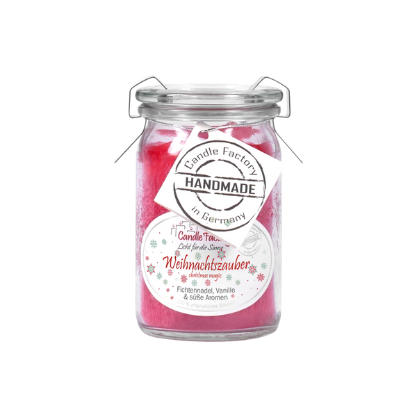 Die Duftkerze/Windlicht „Weihnachtszauber“ Baby-Jumbo von Candle Factory ist eine Kerze im Glasgefäß mit rotem Wachs, Noten von Tannennadeln, Vanille und süßen Aromen. Sie hat einen Metallverschlussdeckel und ein Etikett mit der Aufschrift „Candle Factory HANDMADE in Germany“.