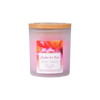 Die Candle Factory Wellness-Duftkerze Zauber der Rose ist ein Milchglas-Kerzenglas mit Holzdeckel, in dem rosa Rosen und eine Stearinmischung für eine beruhigende Atmosphäre in jedem Raum sorgen.