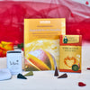 Drei Wellnessprodukte aus dem Geschenkset „Augenblicke der Liebe“ von Original Crottendorfer liegen auf einer hellen Fläche, im Hintergrund sind rote Blütenblätter und ein rotes Tuch zu sehen.