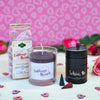 Das Geschenkset „Lieblings Mensch“ von Original Crottendorfer besteht aus einem rosafarbenen Hintergrund mit Herzmuster und Süßigkeiten, einer lila Kerze aus pflanzlichem Stearin im Glas und einer schwarzen Dose mit der Aufschrift „Schön, dass es Dich gibt“, umgeben von rosa Rosen und dekorativem Herzkonfetti.