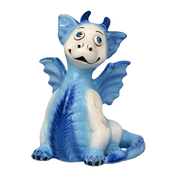 Der KU Drache Blau von Kurilin DECO ist eine blau-weiße Keramikfigur eines lächelnden Drachen mit großen Augen, kleinen Flügeln und einem verspielten Ausdruck.