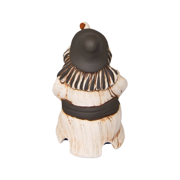 Die KU Hexe „Baba Jaga“ von Kurilin DECO ist eine Keramikfigur in Form einer Person in einem beigen Gewand mit dunklen Akzenten und einem breitkrempigen Hut, der an eine traditionelle Räucherhexe erinnert. Sie ist vom Betrachter abgewandt und hat eine abgerundete Körperform, die ihr etwas Mystisches verleiht.