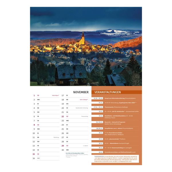 Ein malerisches Dorf bei Sonnenuntergang mit einer Kirche auf einer Anhöhe inmitten von Herbstbäumen. Unten ist der Curth Verlag Kalender "Mein Erzgebirge" 2026 für November und eine Veranstaltungsliste-Veranstaltungen Erzgebirge auf orangem Hintergrund.