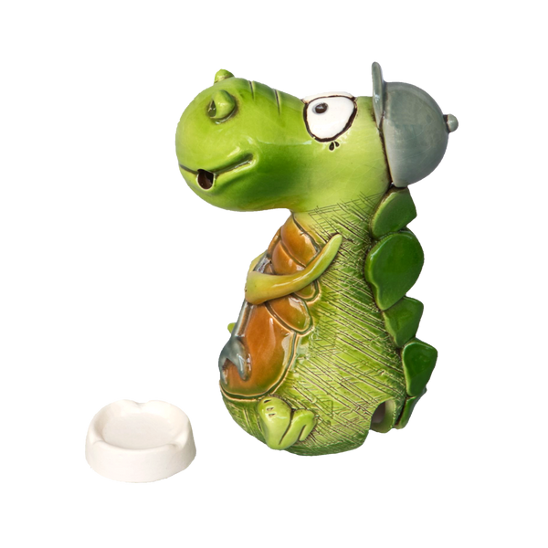 Der KU Räucherdrache mit Schraubenschlüssel von Kurilin DECO ist ein handgefertigter grüner Keramikdrache mit großen Augen und offenem Mund, der eine graue Kappe trägt und einen orangefarbenen Gegenstand hält. Er steht neben einer kleinen weißen Schale, die perfekt für eine Räucherkerze geeignet ist.