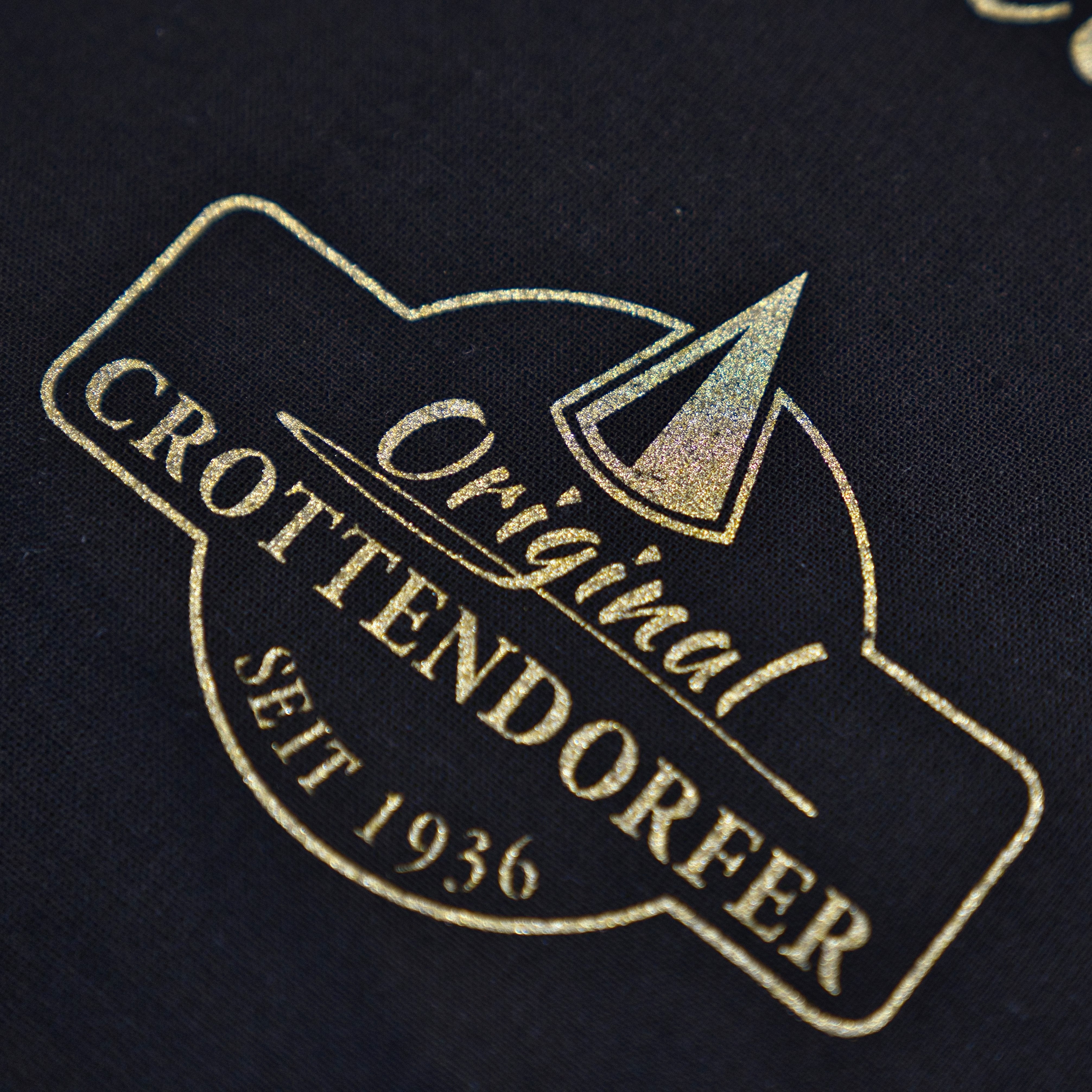 Goldtext und ein geometrisches Design auf Schwarz lauten: Stoffbeutel „Raacherkerzl Definition“ oder „Bitte nicht schubsen ...“ von Original Crottendorfer und spiegeln das erzgebirgische Erbe der Marke wider.
