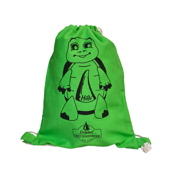 Der Stoffrucksack „Hildi“ von Original Crottendorfer zeigt eine Cartoon-Schildkröte mit „Hilo“ auf dem Bauch, dem Logo und „Seit 1866“. Er besteht aus 100 % Baumwolle und hat robuste weiße Kordelzüge für bequemes Tragen.