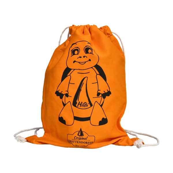 Ein orangefarbener Kinder-Stoffrucksack „Hildi“ von Original Crottendorfer hat eine Cartoon-Schildkröte, den Namen „Hildi“, weiße Kordelzüge und besteht aus 100 % Baumwolle mit der Marke auf der Unterseite.