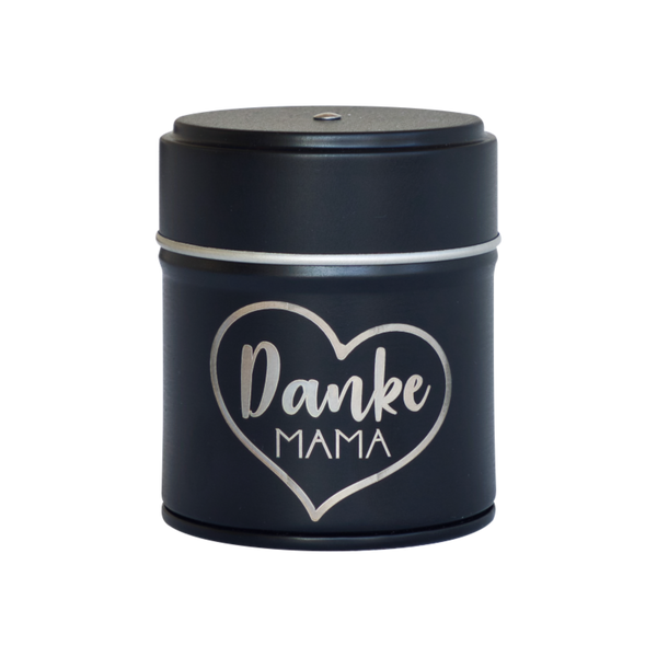 Das Räucherfass Mama von Original Crottendorfer Räucherkerzen ist eine schwarze, runde Dose mit einem Deckel mit silbernem Herzmotiv und „Danke Mama“ in Weiß. Sie eignet sich perfekt zur Aufbewahrung Ihres Räucherkerzenhalters oder anderer kleiner Schätze.