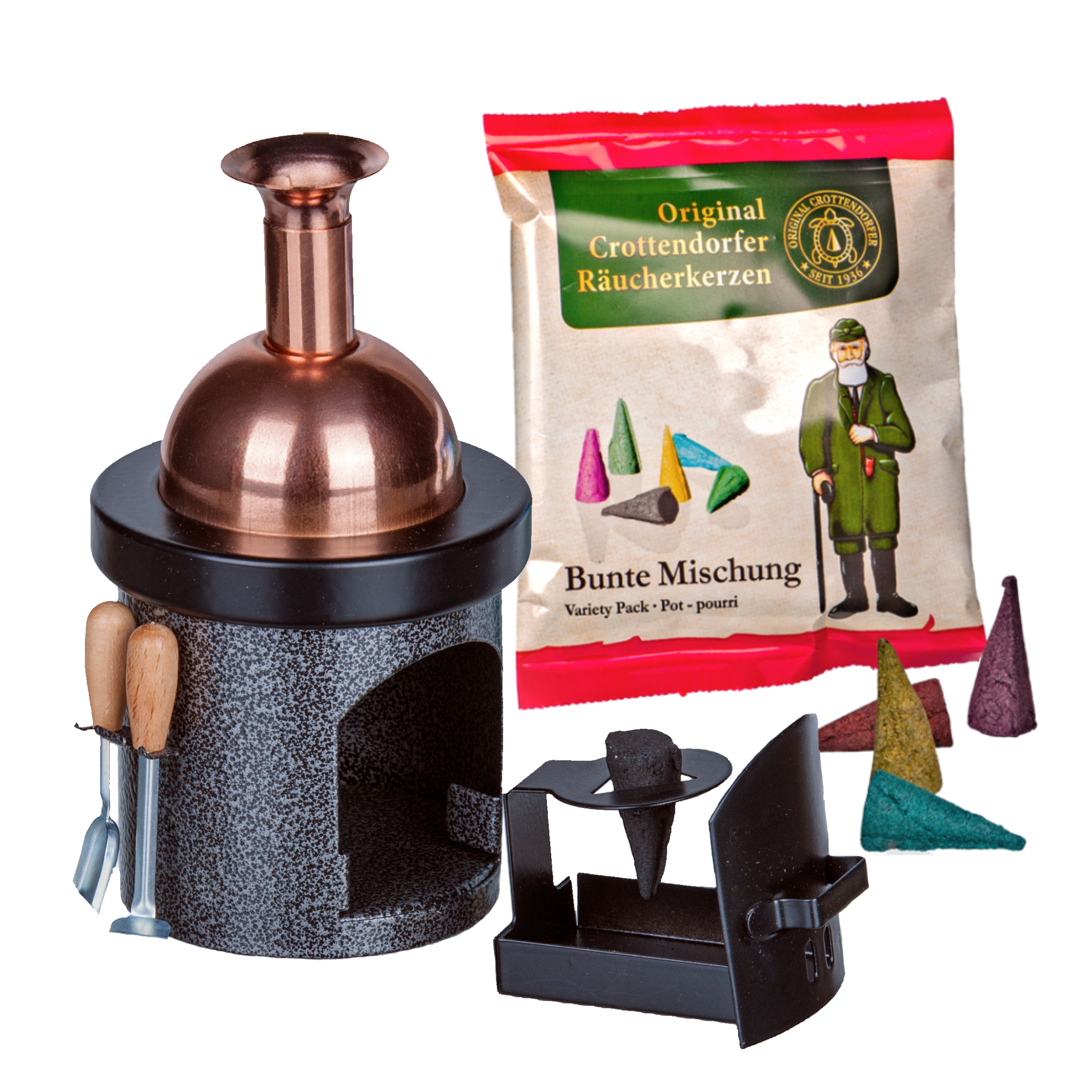 Ein kupfer- und schwarzfarbener Hartmut Richter Räucherofen-Braukessel in Form eines Kamins steht neben einer Packung verschiedener Räucherkegel mit bunten Kegelbildern und einer Figur in einem grünen Mantel. Zu sehen sind auch lose Kegel, ein Aschekasten und ein kleines Werkzeugset.