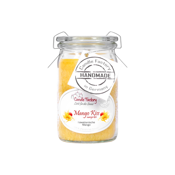 Eine Kerze im Glasgefäß von Candle Factory mit dem Namen Duftkerze/Windlicht „Mango Kiss“ Baby-Jumbo weist ein tropisches Blumendesign und den Slogan „Handmade Duftkerze“ auf. Ihre gelb-orange Farbe spiegelt die leuchtenden Farbtöne einer Mango wider.