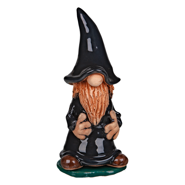 Die Keramik-Räucherfigur Wichtel - schwarz von Original Crottendorfer Räucherkerzen zeigt einen Keramikzwerg mit langem orangenem Bart, schwarzer Zipfelmütze und Gewand auf grünem Sockel. Design und Farbe können aufgrund der handwerklichen Verarbeitung leicht variieren.