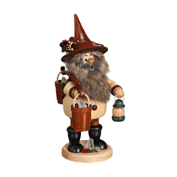 Der DWU Drechselwerkstatt Uhlig Wichtel Erzträger mit Eimer ist eine handgefertigte erzgebirgische Holzfigur eines bärtigen, zwergartigen Räuchermanns mit hohem Hut, Laterne und Eimer. Es steht auf einem runden Sockel, der mit aufwendigem Grün und Beeren verziert ist.