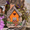 Das Räucherhaus Keramik orange mit Herz von Original Crottendorfer besticht durch seine orangefarbene Fassade, das graue Dach, das herzförmige Fenster und den Kamin. Eingebettet zwischen Blumen und Grünpflanzen in einem Korb bildet es einen bezaubernden Blickfang (Hingucker) für jede Gartenanlage.