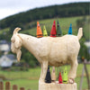 Ziegenbein Otto Orange, Mini Ziegenbein Wilma Waldmoos, Ziegenbein Susi Sandel, Tina Tanne & Mini Ziegenbein Leo Lavendel auf einer großen geschnitzten Holzziege, an den Füßen der Ziege Ziegenbein Willy Weihrauch, Heidi Honig, Mini Ziegenbein Romy rose und Ziegenbein Mila Melisse
