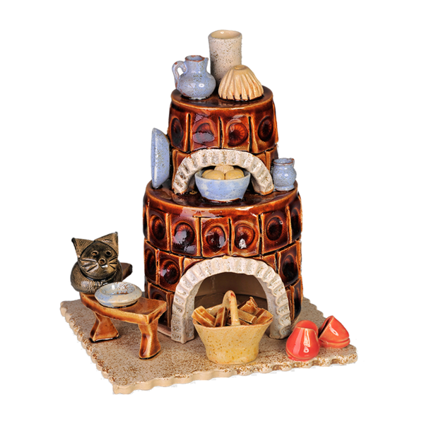 Der Keramik-Räucherofen Kamin der Keramikwerkstatt Carola Busch ist eine dekorative Tonskulptur mit einem handgefertigten braunen Kachelofen und zwei Ebenen, umgeben von kleinen Töpferwaren. Er zeigt eine Katzenfigur auf einer Holzbank neben einem geflochtenen Korb, roten Schuhen und Schüsseln.