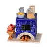 Der Keramik-Räucherofen Mini eckig, blau von der Keramikwerkstatt Carola Busch ist ein dekorativer blauer Keramikofen mit aufwendigen Mustern, auf dem sich eine Obstschale, ein Krug und ein Formkuchen befinden. Am Sockel ist handgefertigtes Brennholz gestapelt, daneben liegen rote Holzschuhe, die seinen charmanten Reiz unterstreichen.