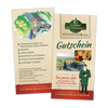 Zwei Gutscheine für das Räucherkerzenland von Original Crottendorfer zeigen farbenfrohe Illustrationen des Veranstaltungsortes und heben Aktivitäten wie Kreativworkshops, einen Streichelzoo und Marktstände hervor. Auf einem Gutschein ist ein Comic-Mann in traditioneller Kleidung abgebildet.