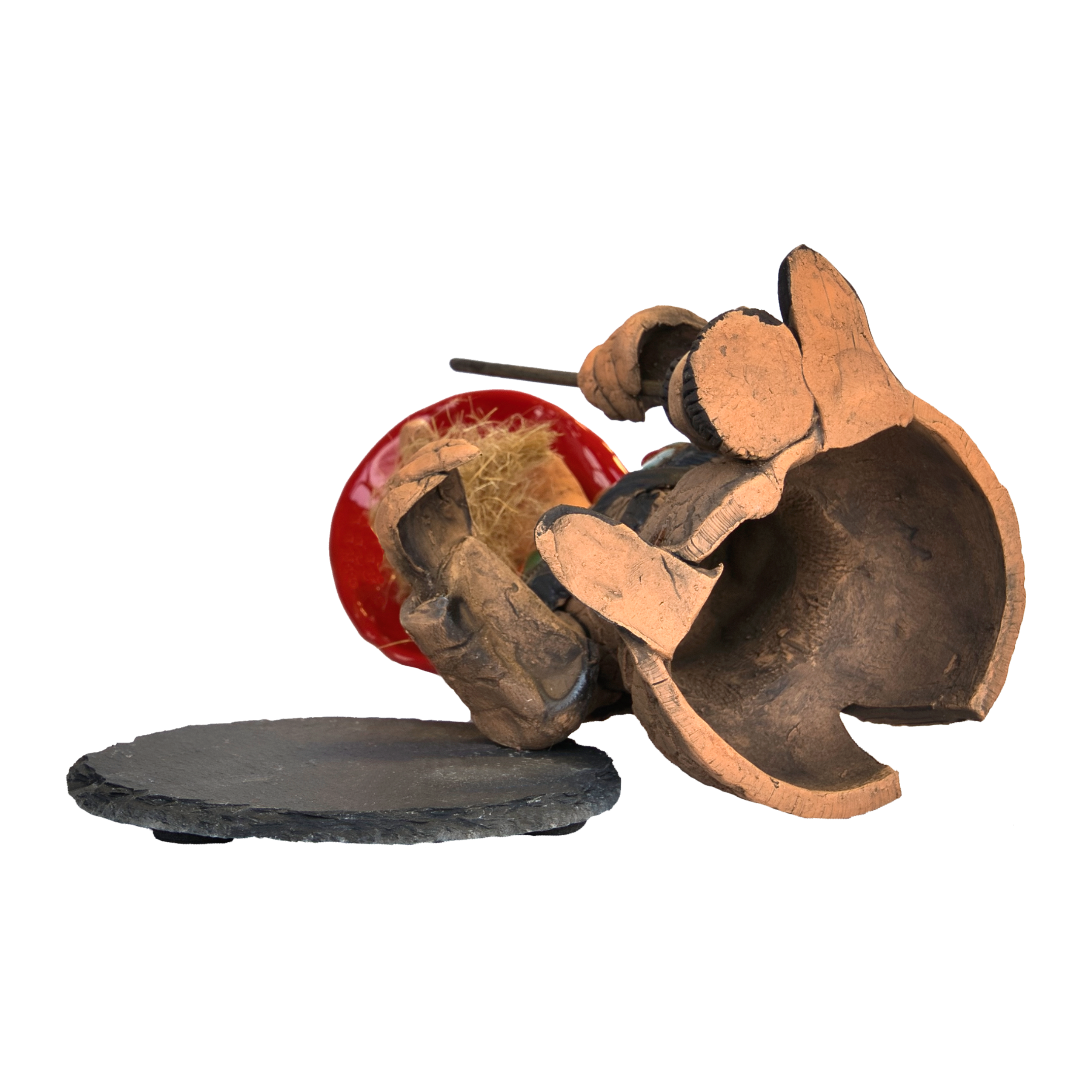 Eine Elefantenskulptur aus Keramik, die an eine Original Crottendorfer „Räucherhexe – Rot, mit Schieferteller“ erinnert, liegt zerbrochen auf der Seite. Sie ist größtenteils hohl und hat eine große Öffnung, die im Inneren abstrakte rote und gelbe Elemente freigibt.