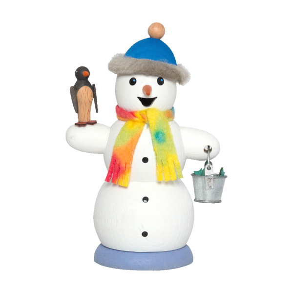 Die Räucherfigur Schneemann mit Pinguin von Drechslerei Kuhnert ist ein bezaubernder Schneemann aus Holz mit einer blauen Mütze, einem bunten Schal, einem Vogel auf einem Arm und einem Metalleimer auf dem anderen. Er steht auf einem blauen Sockel und hat drei schwarze Knöpfe, die seinen Körper schmücken.