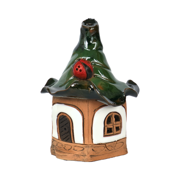 Das Original Crottendorfer Räucherhaus Keramik mini weiß mit Marienkäfer ist ein kleines, liebevoll gestaltetes weißes Keramikhaus mit wellenförmigem grünem Dach, einem roten Marienkäfer auf dem Dach, einer braunen Tür und einem runden Fenster für märchenhaften Charme.