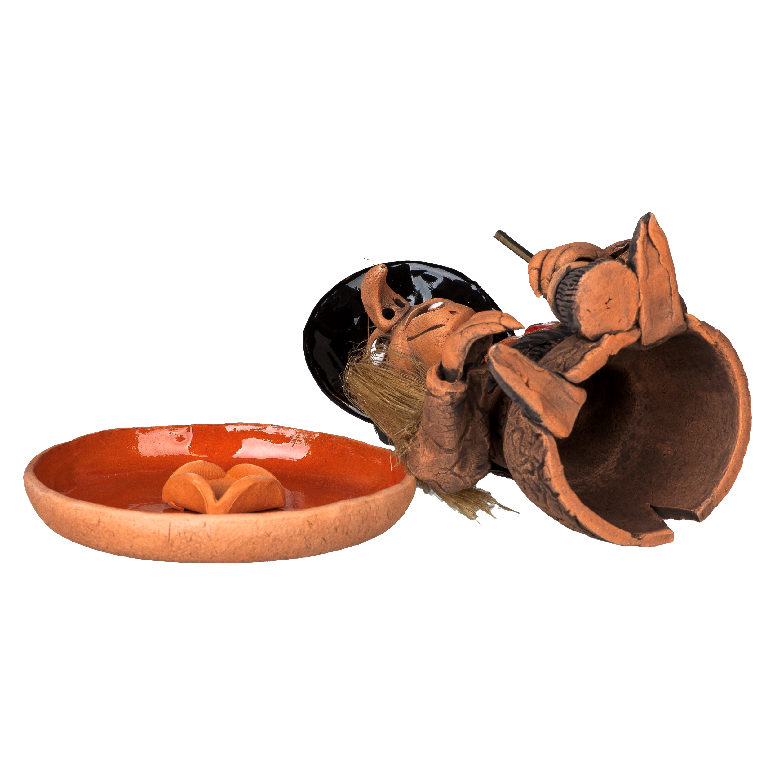 Eine zerbrochene „Räucherhexe mit Keramikteller - Hut schwarz“ von Original Crottendorfer, die einer Hexenfigur mit schwarzem Hut ähnelt, liegt neben einer orangefarbenen Schale mit Mini-Kürbissen. Dieses Unikat ist Teil unserer Limited Edition-Kollektion und in begrenzten Stückzahlen erhältlich.