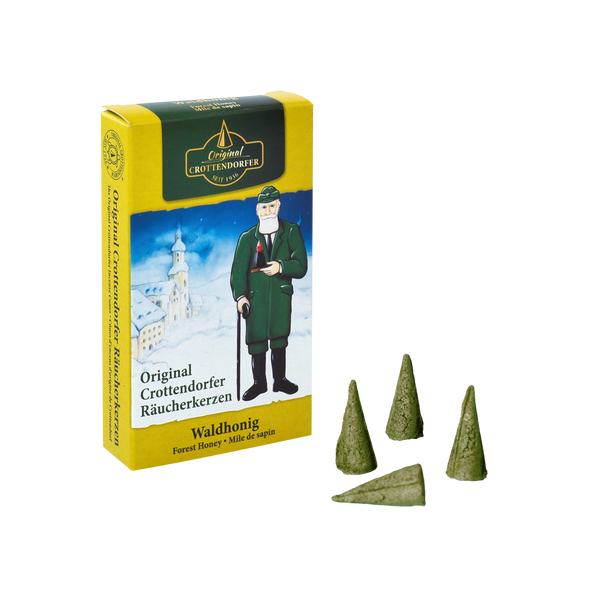 Eine Schachtel Original Crottendorfer Räucherkerzen mit der Aufschrift „Räucherkerzen Waldhonig“ zeigt einen Mann in traditioneller Kleidung. Drei grüne Zapfen, die an Waldhonig erinnern, sind elegant davor angeordnet und versüßen Ihre Sinne.