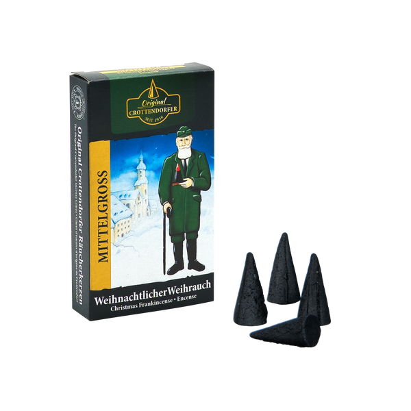 Eine Schachtel mit Räucherkerzen Weihnachtlicher Weihrauch, mittelgroß von Original Crottendorfer Räucherkerzen wird mit einem bezaubernden erzgebirgischen Weihnachtsduft präsentiert. Die Verpackung zeigt eine traditionelle Figur in grünem Mantel auf verschneitem Hintergrund, davor vier balsamische Weihrauchzapfen.