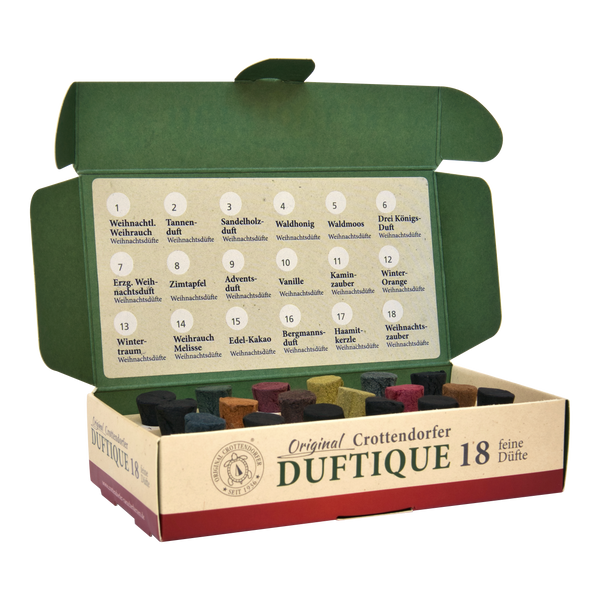 Eine geöffnete Schachtel von Original Crottendorfer Räucherkerzen Duftique 18 feine Düfte - Weihnachtsdüfte & Editionen zeigt 18 bunte Duftkegel wie Tannenduft und Sandelholzduft, fein säuberlich arrangiert mit einer Duftkarte in einer festlichen grün-beigen Verpackung.