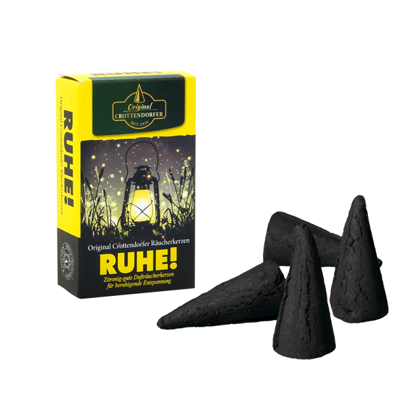 Ein „Original Crottendorfer Räucherkerzen Räucherkerzen RUHE!“ Die Box mit einer leuchtenden Laternengrafik steht neben fünf schwarzen Räucherkegeln und ist ideal, um eine beruhigende Atmosphäre zu schaffen.