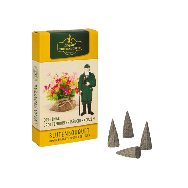Eine gelbe Schachtel mit dem Räucherkerzen Blütenbouquet von Original Crottendorfer Räucherkerzen steht neben vier Räucherkegeln auf weißem Grund, verziert mit einem Mann in grünem und floralem Design.