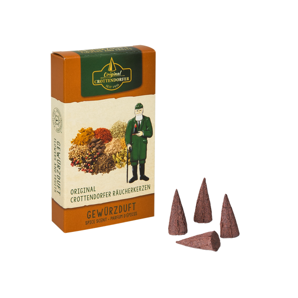 Die Räucherkerzen Gewürzduft-Dose von Original Crottendorfer Räucherkerzen zeigt ein Kräuterbild und eine traditionelle Figur, wobei der Duft Zimtnuancen hinzufügt. Dargestellt sind vier kegelförmige Räucherstücke vor einem dunklen Hintergrund.