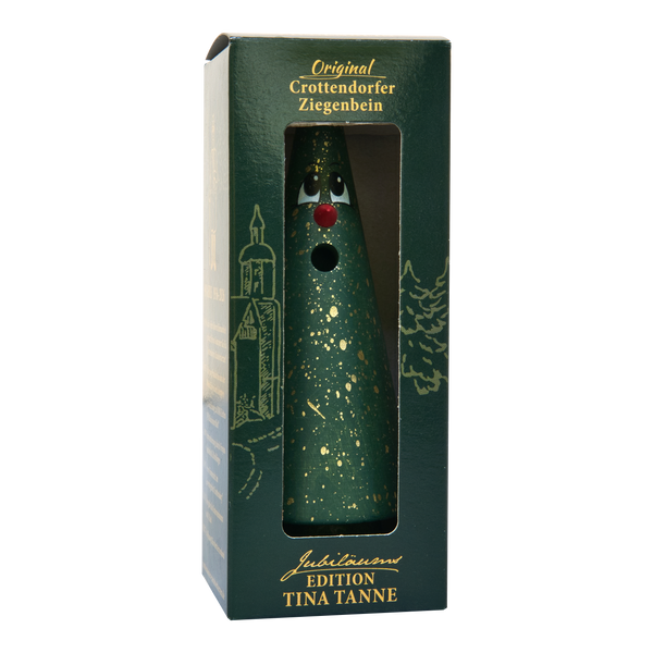 Ein grüner, kegelförmiger Räucherkopf mit goldenen Sprenkeln, roter Nase und Augen, verpackt in einer grünen Schachtel mit der Aufschrift „Crottendorfer Ziegenbein – Jubiläumsausgabe 90 Jahre Tina Tanne“ von Original Crottendorfer Räucherkerzen, als Hommage an die Erzgebirgstradition.