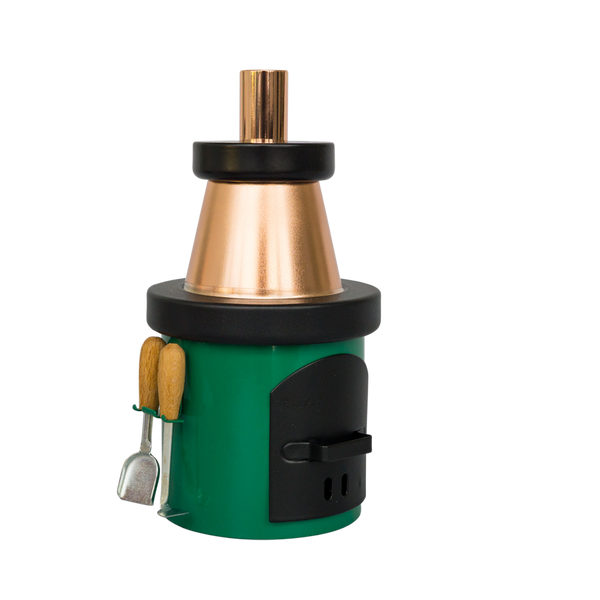 Der Räucherofen Kamin von Hartmut Richter ist ein kompakter, grün-schwarzer Metallofen mit einem kupfernen Schornstein, zwei seitlich angebrachten Ofenbestecken mit Holzgriffen, einer schwarzen Tür und einem runden Aufsatz, alles auf einem schlichten weißen Hintergrund.