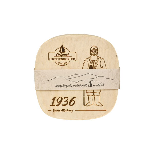 Die „Spanschachtel 1936“ von Original Crottendorfer Räucherkerzen ist eine quadratische Holzschachtel mit einer Zeichnung eines Mannes in traditioneller Tracht, einer Bergkette sowie den Aufschriften „Original Crottendorfer“, „1936“ und „erzgebirgisch. traditionell. maßlind.“ – ein bezauberndes Geschenkset mit Räucherzubehör, ideal für Sammler oder als außergewöhnliches Geschenk.