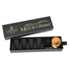 Eine schwarze Schubbox „RAUCH & Heimat“ von Original Crottendorfer Räucherkerzen enthält sechs kegelförmige schwarze Räucherstäbchen, einen kleinen Holzhalter und ein Räuchergitter aus Metall – damit ist sie das perfekte Räucheraccessoire für jeden Raum. Die teilweise geöffnete Schachtel gibt den Blick auf den Inhalt frei und macht sie so zu einem idealen Geschenk für alle, die Wert auf liebevolle Details legen.