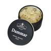 Eine schwarze Blechdose mit der Aufschrift „Dammar in der Schraubdeckeldose“ von Original Crottendorfer Räucherkerzen steht mit halb geöffnetem Deckel da und gibt den Blick auf hellgelbe Harzkristalle frei, die einen frischen, zitronigen und stimmungsaufhellenden Duft versprechen.