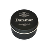 Auf einer schwarzen Blechdose mit der Aufschrift „Dammar in der Schraubdeckeldose“ von Original Crottendorfer Räucherkerzen ist in weißer Schrift der Text „zitronig. ätherisch. frisch.“ zu lesen, wodurch der stimmungsaufhellende, ätherische Duft vor dem weißen Hintergrund besonders hervorgehoben wird.