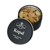 Eine schwarze Blechdose mit der Aufschrift „Kopal in der Schraubdeckeldose“ von Original Crottendorfer Räucherkerzen, deren Deckel einen Spalt offen steht, gibt den Blick auf gelblich-braunes Kopalharz frei, das als holzig, zitronig und süßlich beschrieben wird – ideal für jeden Weihrauchbrenner, der nach reinigenden Eigenschaften sucht.
