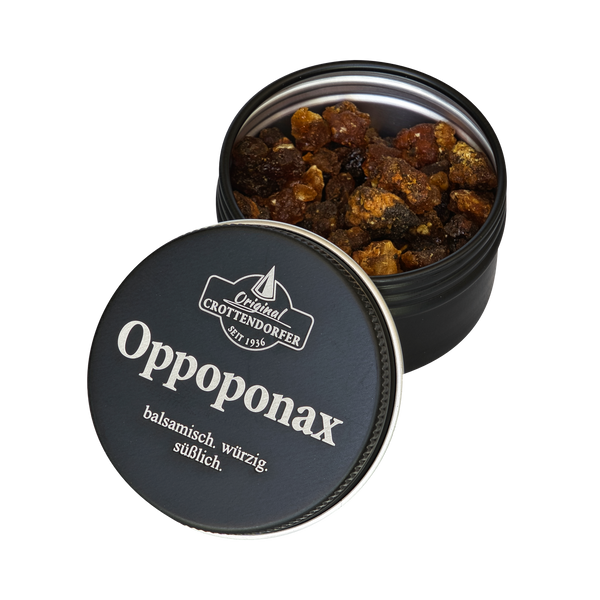Eine runde schwarze Dose mit der Aufschrift „Oppoponax in der Schraubdeckeldose“ von Original Crottendorfer Räucherkerzen steht mit halb geöffnetem Deckel da und gibt den Blick frei auf grobkörniges braunes Räucherharz sowie ein Etikett mit den Angaben „balsamisch, würzig, süßlich“ – was an das Aroma von „Süße Myrrhe“ erinnert.