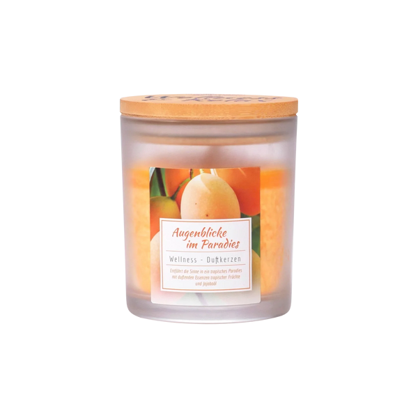 Ein Milchglas-Kerzenglas von Candle Factory mit der Aufschrift Wellness-Duftkerze Augenblicke im Paradies, hergestellt aus Stearin mit einem Holzdeckel und mit Birnen und Orangen auf der Vorderseite.