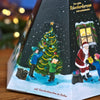 Original Crottendorfer Räucherkerzen – Räucherkerzen-Adventskalender – Pyramide mit Abbildungen von Kindern, die einen Weihnachtsbaum schmücken, und dem Weihnachtsmann, der einem Kind ein Geschenk überreicht.