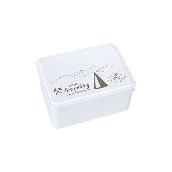 Eine weiße, rechteckige Aufbewahrungsbox von Original Crottendorfer mit Klappdeckel, verziert mit minimalistischen Bergmotiven, einem Bergbausymbol und der Lasergravur „Arzgebirg Certified“ auf dem Deckel.