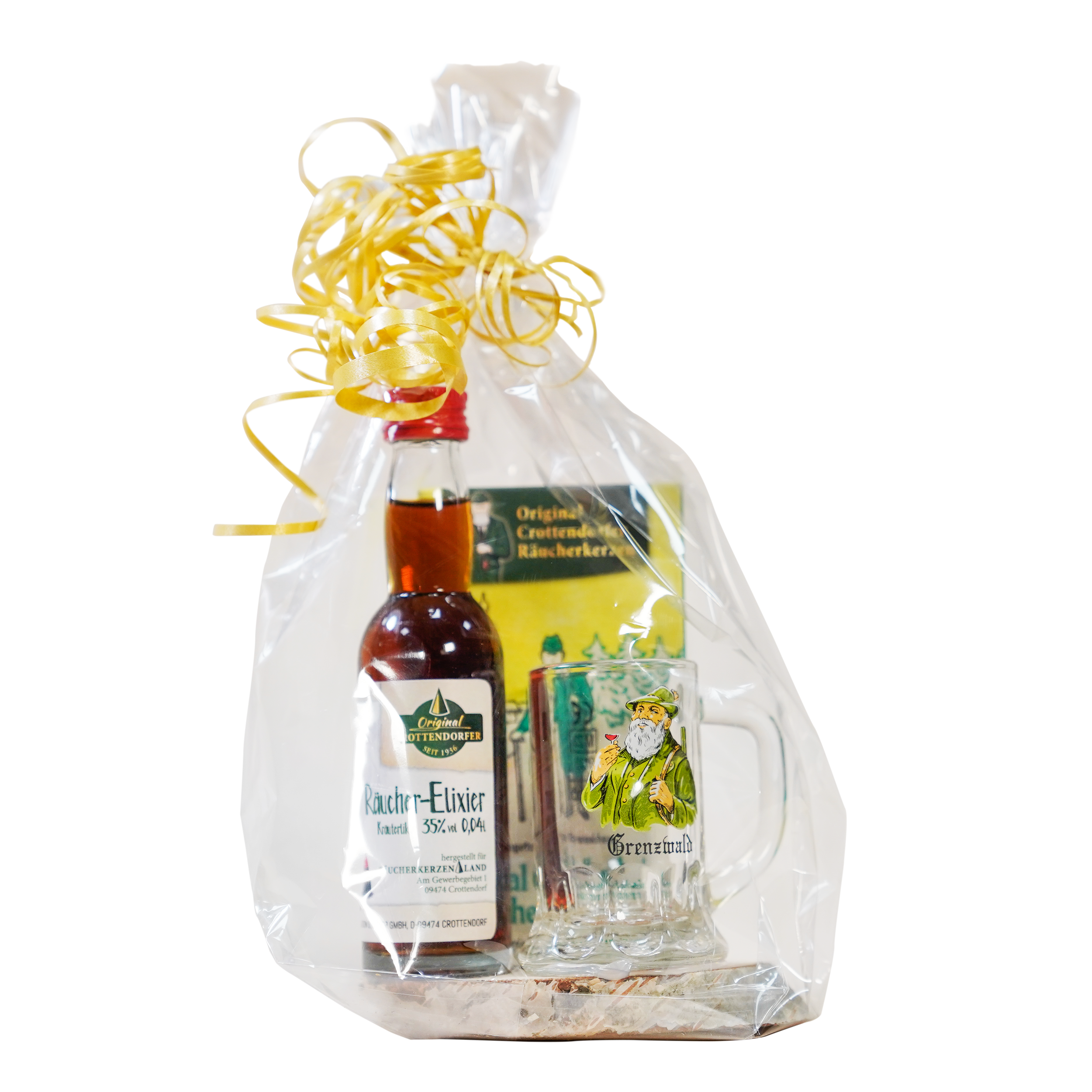 Das Geschenkset Grenzwald von Original Crottendorfer kommt in transparenter Zellophanverpackung mit gelber Schleife und enthält ein Mini-Räucher-Elixier Kräuter, ein Schnapsglas mit Figurenillustrationen .
