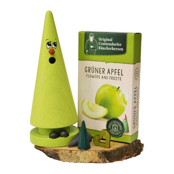 Das Geschenkset „Ziegenbein + Räucherkerzen“ von Original Crottendorfer Räucherkerzen besteht aus einem grünen, kegelförmigen Ziegenbein-Räucherkerzenhalter mit Holzsockel, ergänzt durch Räucherkegel und ein Miniaturhäuschen, die zusammen eine bezaubernde Dekoration bilden.