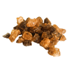 Auf einem weißen Hintergrund liegt ein Haufen unregelmäßiger brauner und bernsteinfarbener Kristalle, die an Rohzucker erinnern – eine Anspielung auf das Räucherharz Opoponax aus der Serie „Original Crottendorfer Räucherkerzen“.