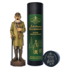 Ein hölzerner Jubiläums Räuchermann von Original Crottendorfer Räucherkerzen steht neben seiner großen dunkelgrünen Geschenkdose und einer kleinen runden Dose, die alle mit klassischen gold-weißen Motiven und Illustrationen versehen sind.