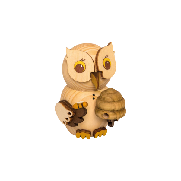 Der Mini Eule Imker von Drechslerei Kuhnert ist eine Eulenfigur aus Holz mit detailreichen Schnitzereien für Augen, Schnabel und Flügel. Sie hält ein Objekt, das einem Bienenstock ähnelt, und hat eine hellbraune Holzoberfläche.