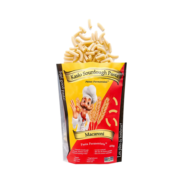 Eine Packung Miriquidi Sauerteig Pasta - Makkaroni von Miriquidi Sauerteig Pasta, aus der ungekochte Makkaroni-Nudeln herausquellen, mit einem lächelnden Koch und Weizen auf einem roten und gelben Hintergrund. Sauerteignudeln für bessere Verdaulichkeit.